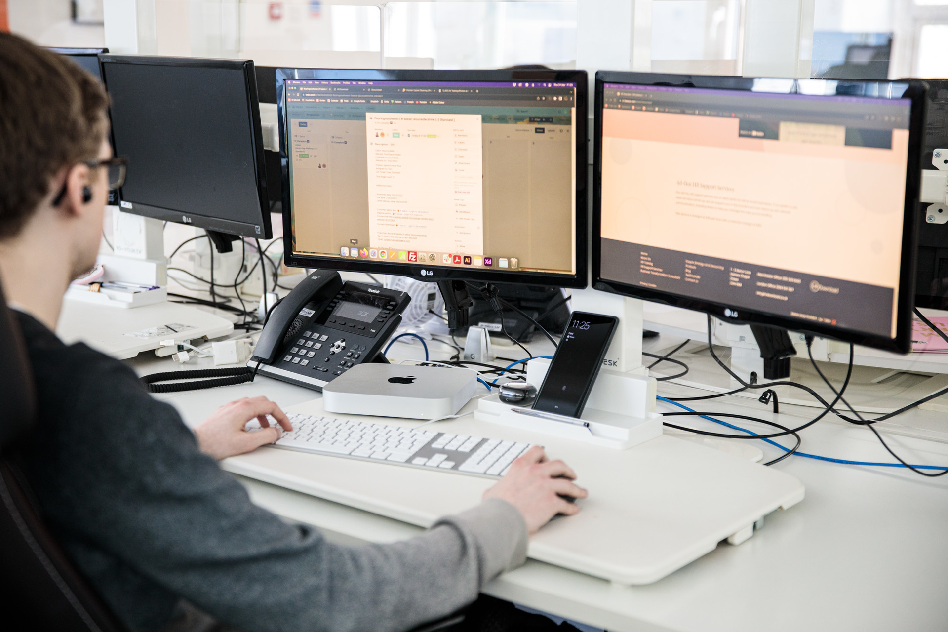A website designer sat at his desk looking at his desktop computer